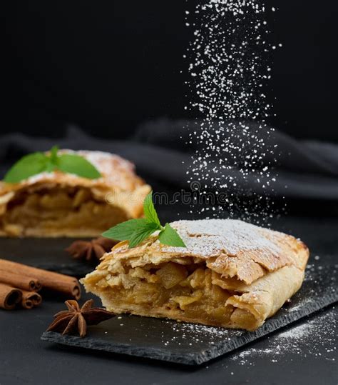 Thematic photo of a freshly baked strudel sprinkled with powdered sugar on a cutting board