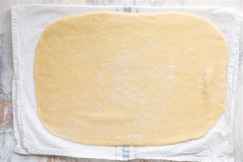 Infographic showing the steps of rolling out strudel dough and applying filling