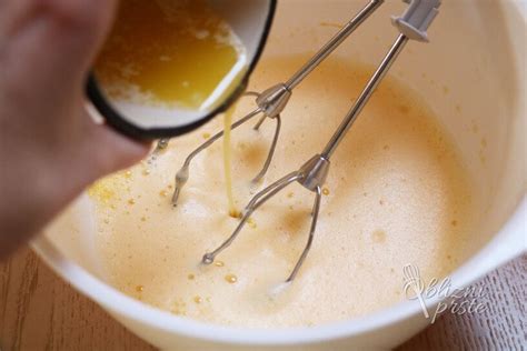 Prikaz ročnega vmešavanja stepenih beljakov v maso za vaflje z lopatko.