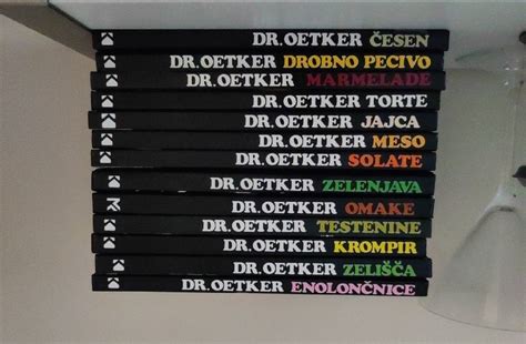 Zbirka različnih kuharskih knjig na polici, ki čakajo na osebno posvetilo.