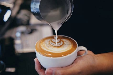 Tematska fotografija skodelice kave z avtomatskim aparatom v sodobni kuhinji