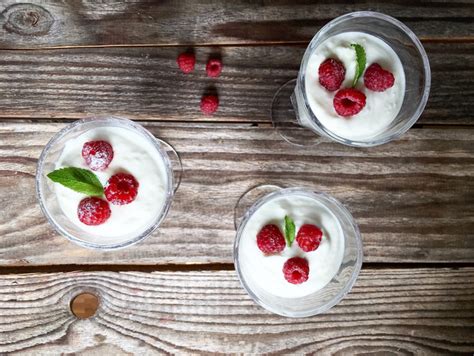 Fotografija smetanove kreme, postrežene v kozarcih s sadjem
