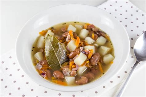 Fotografija sestavin za juho s fižolom in krompirjem, vključno z zelenjavo in začimbami