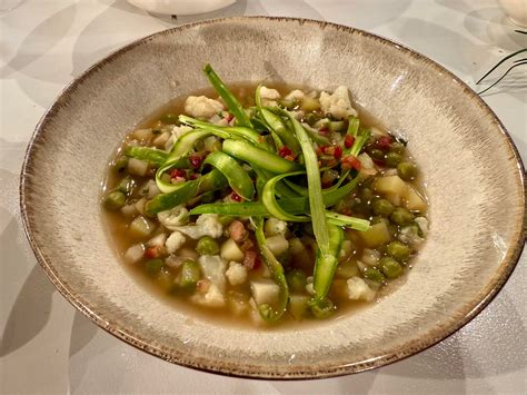 Fotografija cvetače, narezane na cvetke, ki se kuha v lonec.