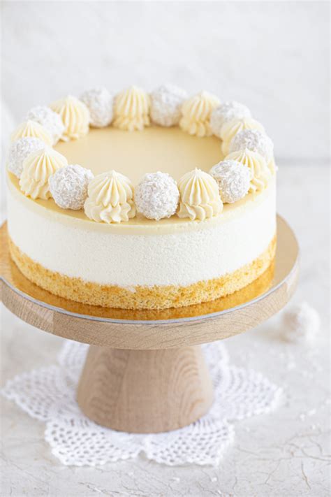 slika prefinjeno okrašene torte z belim čokoladnim moussom in kokosovim posipom