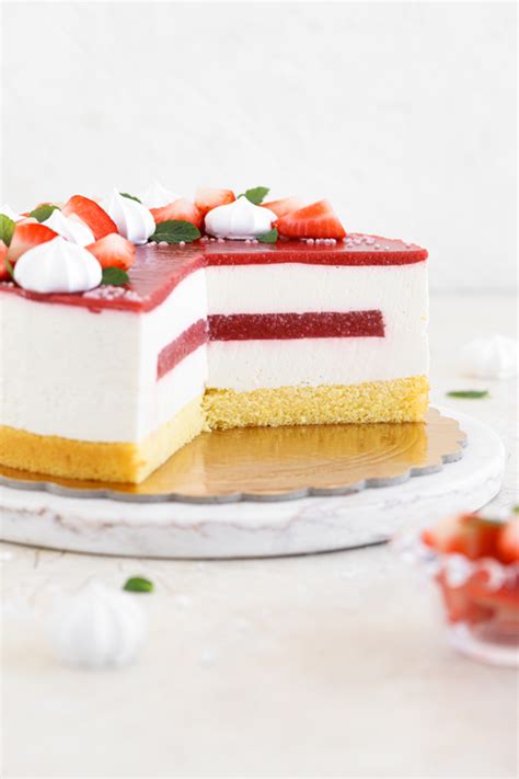 Fotografija sveže pripravljene jagodne torte, okrašene s celimi jagodami in jagodnim prelivom
