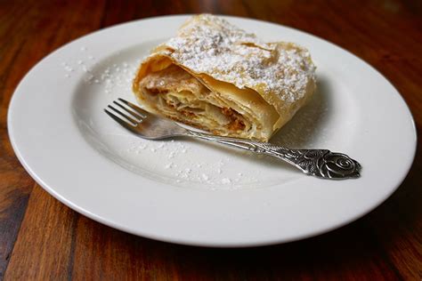 Kolaz s slikami različnih jedi iz vlečenega testa: jabolčni zavitek, štruklji, burek, bougatsa.