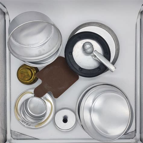 Fotografija različnih kamping setov za kuhanje, razporejenih po mizi