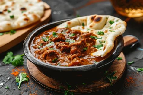 Thematic photo of naan bread with Indian spices and a bowl of curry