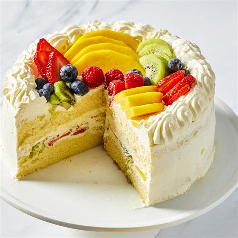 Layered dessert in a rectangular form, showing sponge cake, cream, and marbled fruit topping