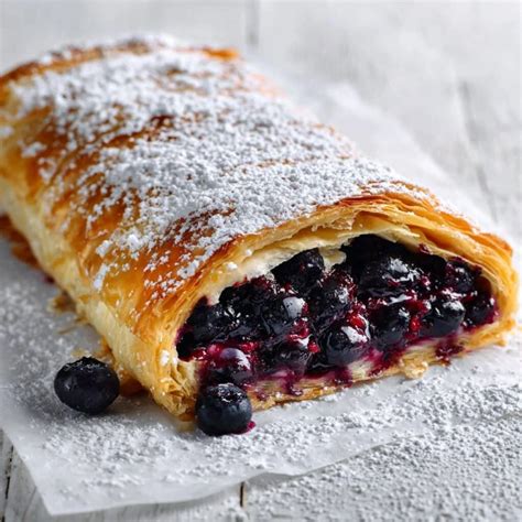 Thematic photo of a fresh blueberry strudel on a wooden board