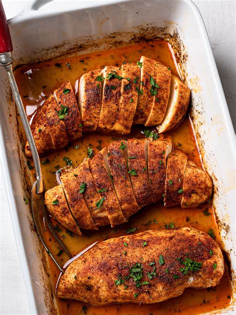 Thematic photo of baked chicken breast with sesame seeds and roasted vegetables in a baking dish