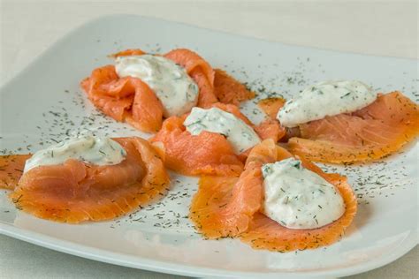 fotografija dimljenega lososa na elegantnem krožniku s kozarcem belega vina