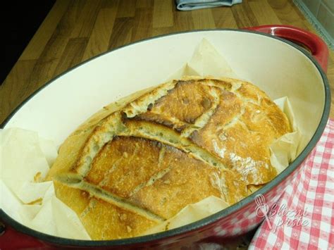 Pekač z narezanimi rezinami mlečnega kruha, ki kažejo mehko sredico in zlato skorjico.