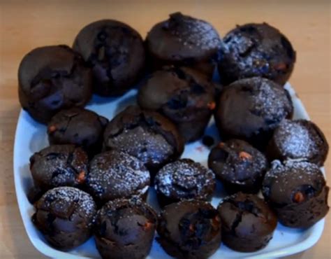 Fotografija sveže pečenih čokoladnih muffinov z Nutella polnilom, posutih s sladkorjem v prahu