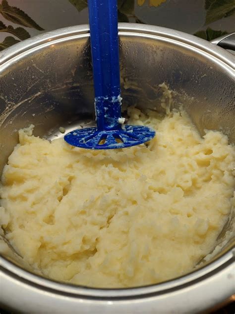 Pripravljen pire krompir v posodi s tlačilko