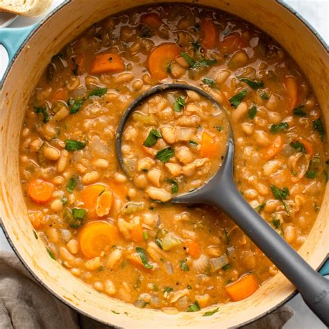 Thematic photo of bean stew with pasta being served in a rustic bowl with sour cream and cheese