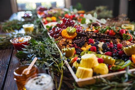 Ilustracija skupine ljudi v tradicionalnih oblačilih pred majhno stojnico s hrano v orientalskem mestu.