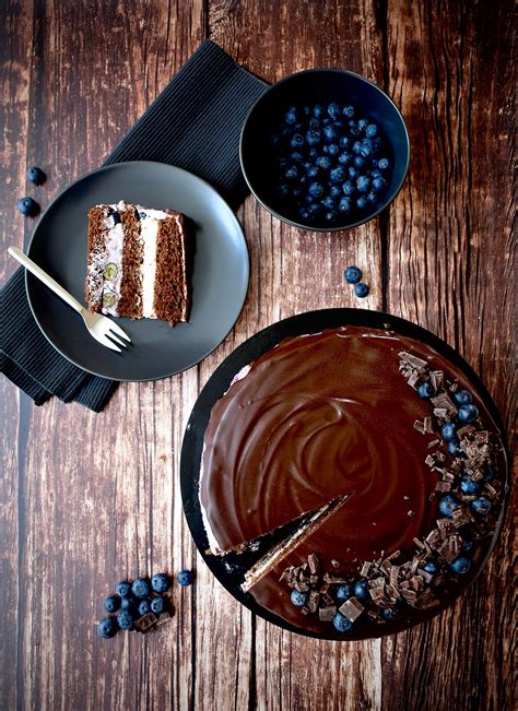 Tematska fotografija prelepe borovničeve torte s čokoladnim oblivom in svežimi borovnicami