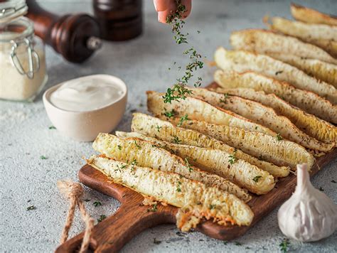 fotografija pripravljenega pečenega koromača s česnom, peteršiljem in parmezanom, postreženega ob kosu mesa