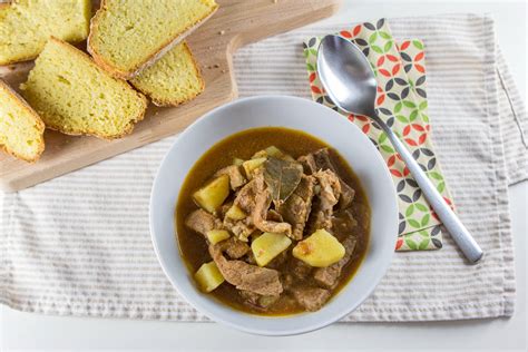 Sestavine za pripravo krompirjevega golaža: krompir, goveje meso, čebula, česen, paprika, paradižnik in sveža zelišča.