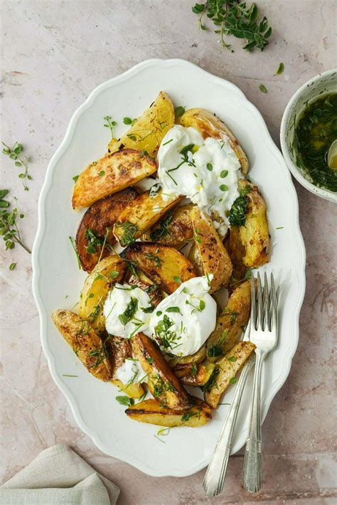 narezan krompir, premazan z zeliščno mešanico, na pekaču