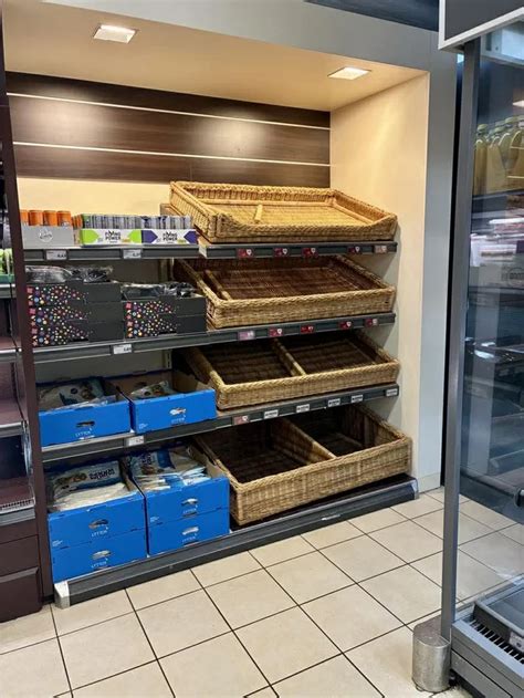 Fotografija sodobne pekarne znotraj trgovine HOFER, kjer so police polne sveže pečenega kruha in peciva.