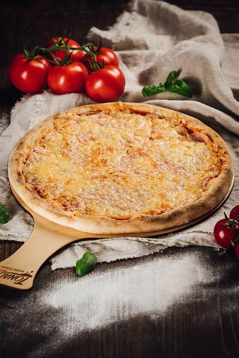 Tematsko foto: Velika, okrogla pizza, ki sega čez rob krožnika