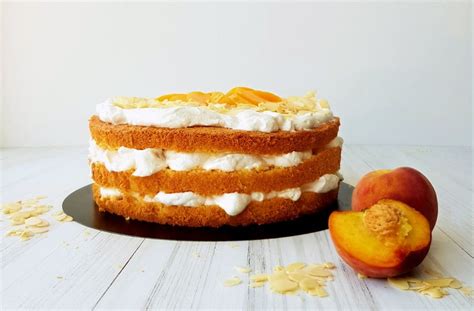 Nadev iz mascarpone kreme z narezanimi breskvami v posodi.
