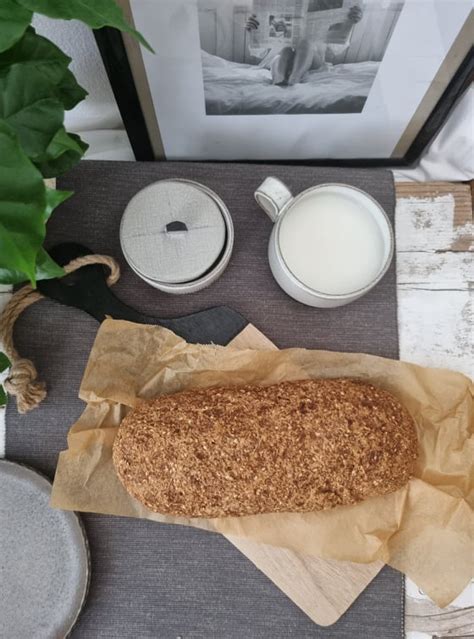 Fotografija vzhajajočega kruha v modelu, premazanega z mlekom in posipanega s sezamom.