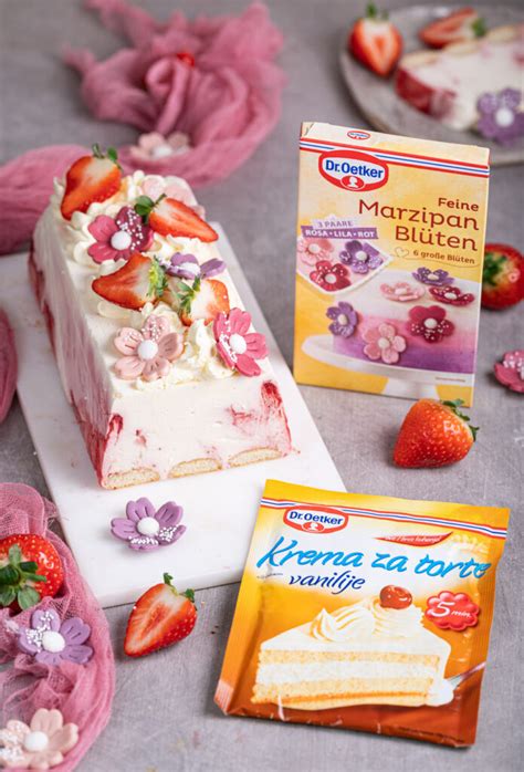 Fotografijo dekorirane bezgove torte z jagodami in cvetovi