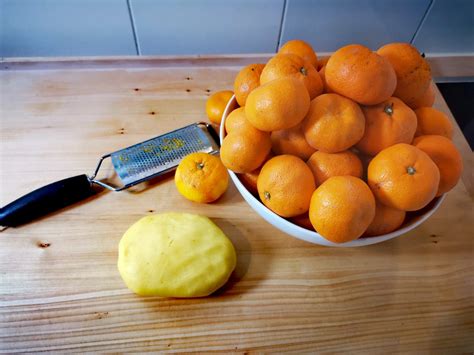 fotografija kozarcev z domačo marmelado, kjer se vidi nežno oranžna tekstura kakija z drobci pomarančne lupinice