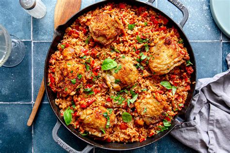 Tematska fotografija tajskega rdečega curryja v skledi z rižem in svežimi zelišči