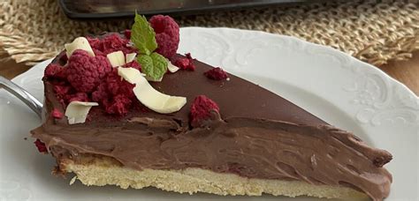 Končana čokoladna torta brez moke in sladkorja, okrašena z Raffaello kroglicami in mandljevim krokantom