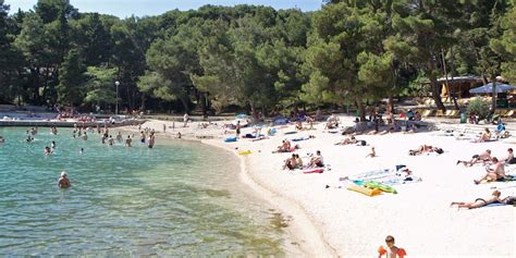 Peščena plaža An Bang z nekaj senčniki in palmovimi listi