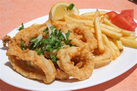 Fotografija sveže pripravljenih ocvrtih lignjev s pomfritom