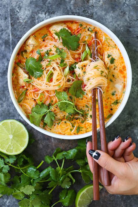Bowl of spicy Thai coconut curry soup with rice noodles and vegetables