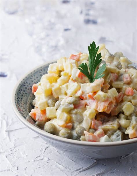 Skupina svežih sestavin za francosko solato (krompir, korenje, grah, jajca, kumarice, majoneza)