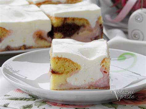 Sestavljena tortica iz keksov, jagod in pudinga, okrašena s smetano in kakavom.