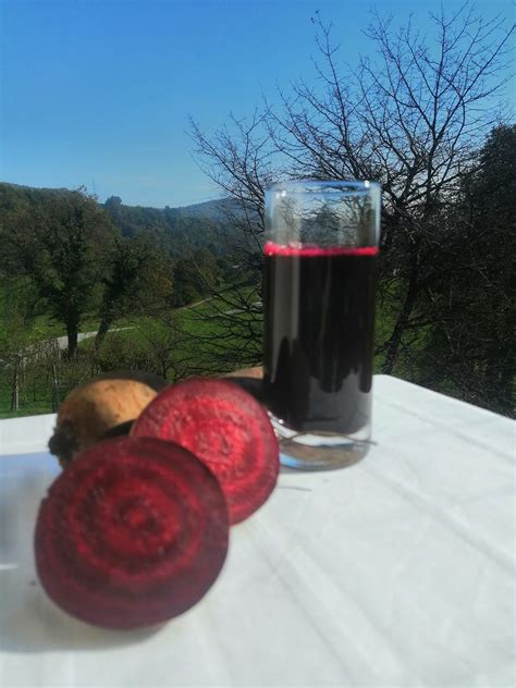 Sveže stisnjen sok rdeče pese v kozarcu, poleg cele in narezane pese