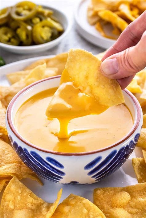Thematic photo of nacho cheese sauce in a bowl with nachos