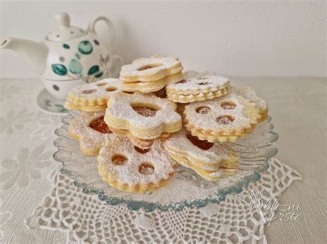 Prikaz pripravljenih linzer piškotov z marmelado med dvema kosoma.