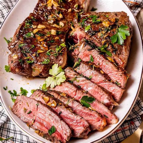 priprava mesa za pečenje: sirloin steak na deski pred začinjenjem