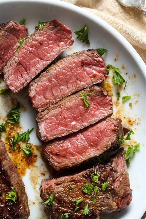 pečen sirloin steak počiva na deski, pokrit s folijo