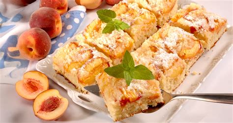 Prikaz končne mandljeve pite z breskvami na krožniku.