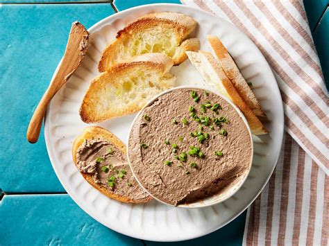 Thematic photo of homemade liver pâté on bread with fresh herbs