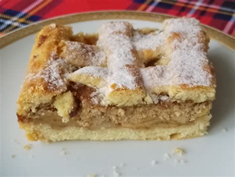 Zlato pečena domača jabolčna pita na rustikalnem krožniku