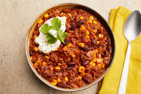 Fotografija servirane sklede Chili con Carne z vsemi dodatki