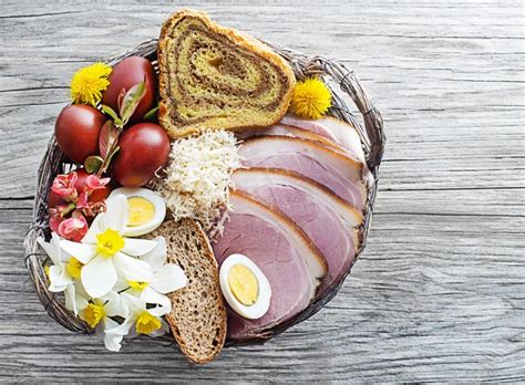 Fotografija tradicionalno pripravljene košarice z velikonočnimi jedmi (kruh, pirhi, šunka, hren).