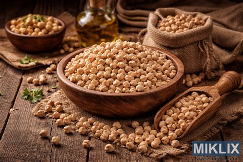 različne stročnice na leseni mizi, skodelica lečine juhe na leseni deski z žlico ob skodelici